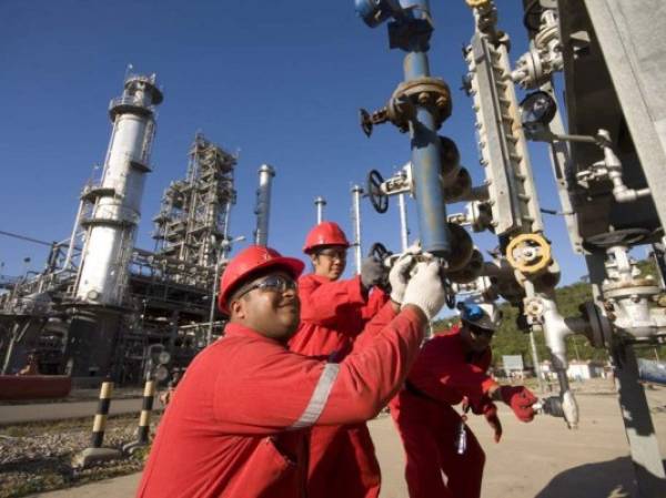 Operarios trabajan en la extractora de petróleo de Puerto La Cruz, ciudad de Anzoátegui, Venezuela. En junio de 2014, el crudo costaba US$104 el barril, hoy está en US$45.