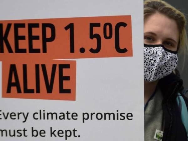 Una activista climática sostiene un cartel mientras protesta durante la Conferencia de Cambio Climático COP26 de la ONU en Glasgow el 12 de noviembre de 2021. Un borrador de declaración de la cumbre COP26 el viernes pidió a las naciones que alivien su dependencia de los combustibles fósiles mientras las conversaciones entraban en sus últimas horas sin señal de lograr los recortes de emisiones necesarios para limitar el calentamiento global a 1,5 ° C. Foto AFP