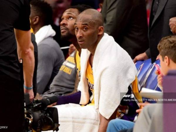 (FILES) In this file photo Kobe Bryant #24 of the Los Angeles Lakers looks on from the bench late in the fourth quarter against the Utah Jazz at Staples Center on April 13, 2016 in Los Angeles, California. - The towel that Kobe Bryant wore over his shoulders during his farewell speech after his final National Basketball League game has fetched over $33,000 at auction, the US media said on March 29, 2020.With the towel draped around him to help mop up his sweat, the Los Angeles Lakers superstar closed his speech with his signature phrase, 'Mamba Out.'The towel ended up in the hands of a fan as Bryant walked off the court and was then sold several times before the latest online auction. (Photo by Harry How / GETTY IMAGES NORTH AMERICA / AFP)