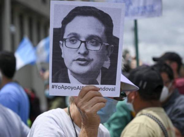 A demonstrator holds a portrait of dismissed Guatemala's Special Prosecutor against Impunity, Juan Francisco Sandoval, during a protest to demand the resignation of Guatemalan President Alejandro Giammattei and Guatemala's Attorney General Maria Consuelo Porras, outside the Public Ministry's headquarters in Guatemala City on July 24, 2021. (Photo by Johan ORDONEZ / AFP)