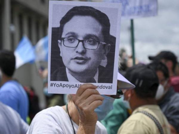 A demonstrator holds a portrait of dismissed Guatemala's Special Prosecutor against Impunity, Juan Francisco Sandoval, during a protest to demand the resignation of Guatemalan President Alejandro Giammattei and Guatemala's Attorney General Maria Consuelo Porras, outside the Public Ministry's headquarters in Guatemala City on July 24, 2021. (Photo by Johan ORDONEZ / AFP)