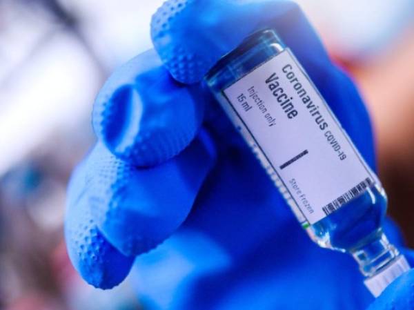 Image of Hand holds Coronavirus Covid-19 Vaccine glass bottle.