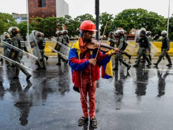 El activista opositor Wuilly Arteaga es uno de los símbolos de la protesta contra Nicolás Maduro por su peculiar forma de mostrar su descontento: tocanco el violín. Artega, de 23 años, fue arrestado el 27 de julio en la huelga de 48 horas. Foto AFP.