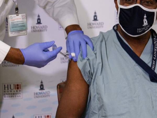 Dr. Hugh Mighty, Dean of the College of Medicine at Howard University, receives a Covid-19 vaccine at Howard University Hospital in Washington, DC, on December 15, 2020. (Photo by NICHOLAS KAMM / AFP)