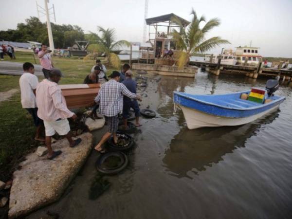 Relatives carry the coffin of a loved one who died on the eve when a boat capsized off the Atlantic coast of Honduras, at Catarasca Naval Base in Puerto Lempira, Honduras, on July 4, 2019. - Honduran authorities said Thursday they are investigating the causes of an accident in which at least 27 people died after their fishing boat sank in the remote Mosquitia coastal region off the Caribbean coast after heading out to sea when a seasonal ban on lobster fishing was lifted. (Photo by Jorge CABRERA / POOL / AFP)