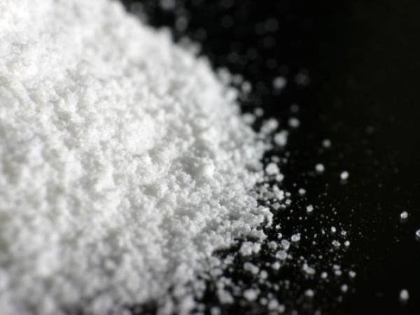 A heap of white powder on black floor.