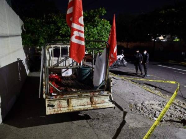 Police guard a truck that carried supporters of the political party Farabundo Marti Front (FMLN), earlier attacked with firearms while returning from political activity, near Rosales Hospital, in San Salvador, on January 31, 2021. - An attack by strangers in the downtown San Salvador on a caravan of FMLN militants left 'two deceased and five injured' on Sunday, the attorney general's office reported. (Photo by MARVIN RECINOS / AFP)