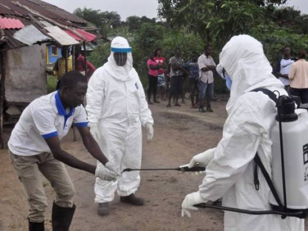 Health workers wash their hands after taking a blood specimen from a child to test for the Ebola virus in an area where a 17-year old boy died from the virus on the outskirts of Monrovia, Liberia, Tuesday, June 30, 2015. Liberian authorities on Tuesday quarantined the area where the corpse of the boy was found, sparking fears this West African country could face another outbreak of the disease nearly two months after being declared Ebola-free. (AP Photo/ Abbas Dulleh)