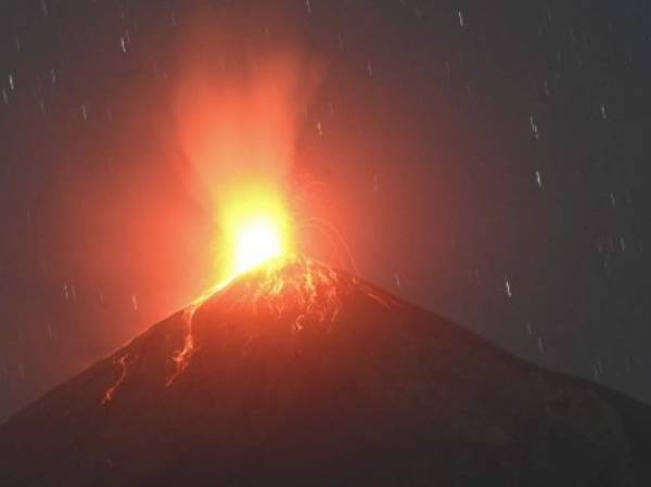 The Fuego volcano, as seen from Alotenango, a municipality in Sacatepequez department 65 km southwest of Guatemala City, erupts on February 14, 2021. - Civil Protection Authorities of Guatemala increased surveillance on Sunday to the increase in eruptive activity of the volcano of Fuego, in the southwest of the country, which has dispersed ash particles in nearby municipalities and records avalanches of incandescent material. (Photo by Johan ORDONEZ / AFP)