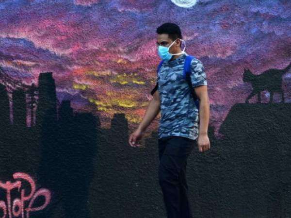 A woman wears a face mask during the COVID-19 pandemic, at a street market in Tegucigalpa on June 8, 2020, after the governmet announced the resumption of economic activity. - Honduras reopens its business activities, cautiously, after almost three months of confinement, though, according to experts, at the worst time to do so due to the rapid rise of the coronavirus and at high risk of closing again. (Photo by ORLANDO SIERRA / AFP)