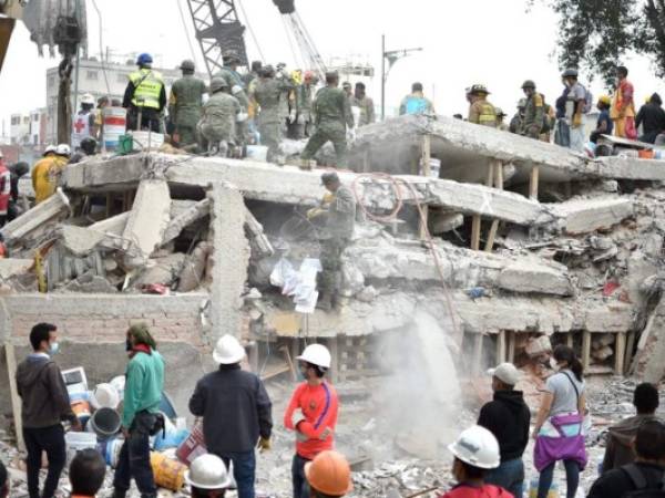Rescuers and volunteers work clearing from rubble and debris the site where a multistory building was flattened by a 7.1-magnitude quake on the eve searching for survivors, in Mexico City, on September 20, 2019. Rescuers frantically searched Wednesday for survivors of a powerful earthquake that killed more than 200 people in Mexico on the anniversary of another massive quake that left thousands dead and still haunts the country. / AFP PHOTO / YURI CORTEZ