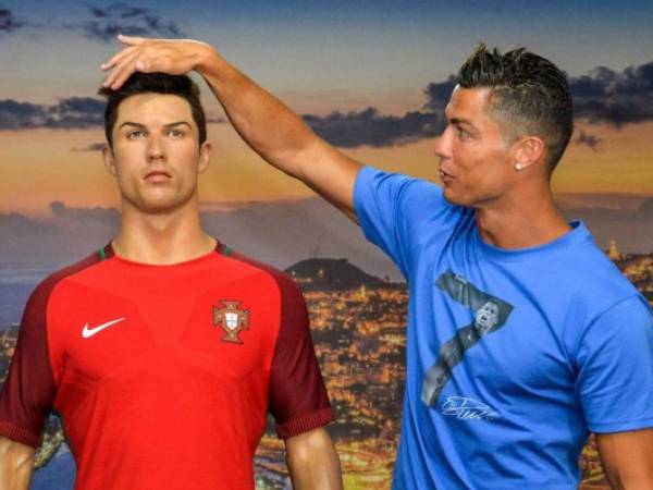 Portugese forward Cristiano Ronaldo poses next to a wax statue representing himself during a visit to the new location of the CR7 museum dedicated his professional career at Funchal, on the Portuguese island of Madeira on July 23, 2016. (Photo by JOANA SOUSA / AFP)