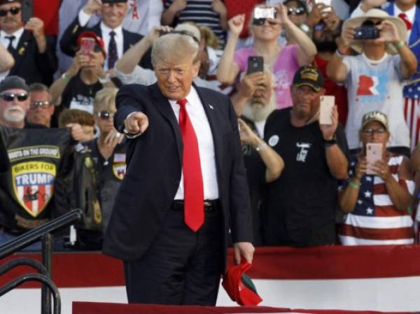 Former US President Donald Trump points to the crowd as he arrives for his campaign-style rally in Wellington, Ohio, on June 26, 2021. - Donald Trump held his first big campaign-style rally since leaving the White House, giving a vintage, rambling speech Saturday to an adoring audience as he launched a series of appearances ahead of next year's midterm elections.The former president, who has been booted from social media platforms and faces multiple legal woes, has flirted with his own potential candidacy in 2024, but in the 90-minute address at a fair grounds in Ohio he made no clear mention of his political future, even when the crowd chanted 'four more years! four more years!' (Photo by STEPHEN ZENNER / AFP)