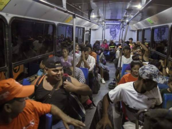 Central American migrants -mostly Hondurans- moving in a caravan towards the United States, board a bus at La Concha phytosanitary station in the Mexican state of Sinaloa, on November 13, 2018. - US Defence Secretary Jim Mattis said Tuesday he will visit the US-Mexico border, where thousands of active-duty soldiers have been deployed to help border police prepare for the arrival of a 'caravan' of migrants. (Photo by ALFREDO ESTRELLA / AFP)