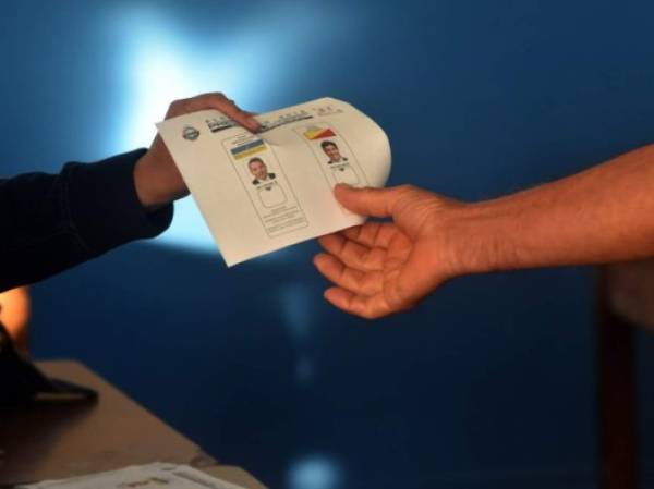 Un votante recibe la papeleta para votar en las elecciones presidenciales en segunda vuelta de Costa Rica. AFP PHOTO / Rodrigo ARANGUA