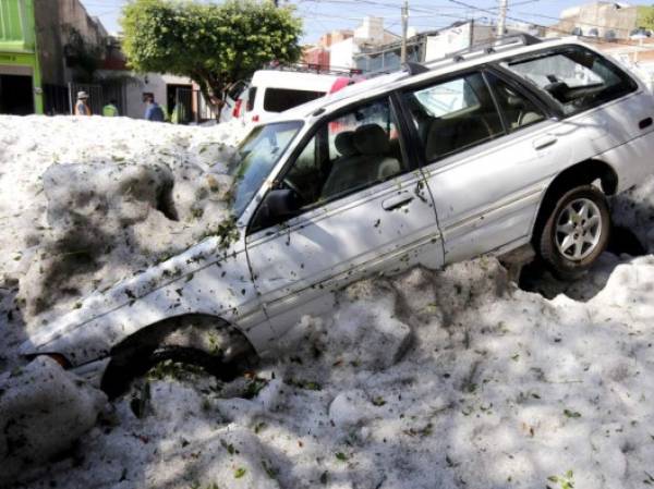 A vehicle is seen trapped on June 30, 2019 after a hail storm fell in Guadalajara, Jalisco State, Mexico. - A freak hail storm on Sunday struck Guadalajara, one of Mexico's most populous cities, shocking residents and trapping vehicles in a deluge of ice pellets up to two metres deep. (Photo by Ulises RUIZ / AFP)