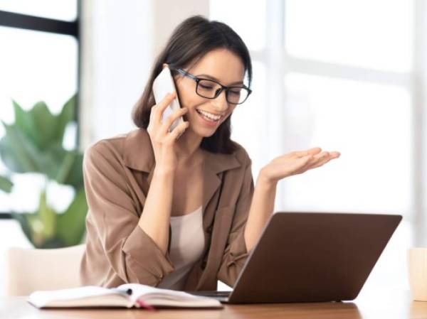 Informal Call. Happy young woman in glasses calling her friend, talking and asking about something, using laptop