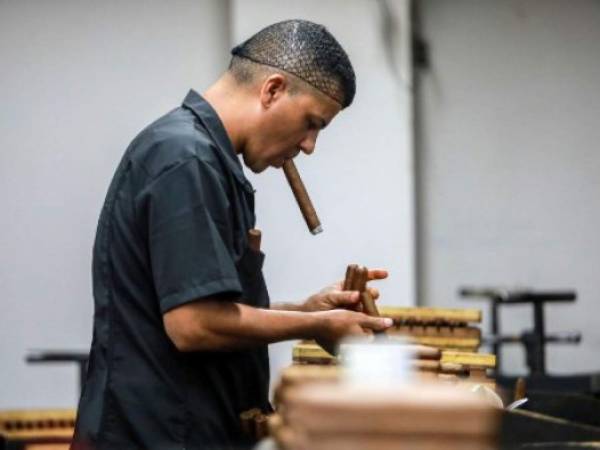 A worker smokes a cigar at a cigar factory in Esteli, Nicaragua on May 17, 2019. - Nicaragua is consolidating as the largest exporter of cigars to the US, an industry which was born in the fertile lands of Esteli. (Photo by INTI OCON / AFP)