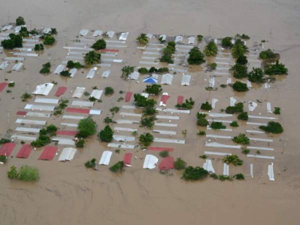 (FILES) In this file photo taken on November 18, 2020 Aerial view an area around San Pedro Sula, 240 km north of Tegucigalpa, flooded by the overflowing of the Chamelecon river after the passage of Hurricane Iota, taken on November 18, 2020. - Storm Iota, which made landfall in Nicaragua as a 'catastrophic' Category 5 hurricane Monday, killed at least ten people as it smashed homes, uprooted trees and swamped roads during its destructive advance across Central America. (Photo by Orlando SIERRA / AFP)