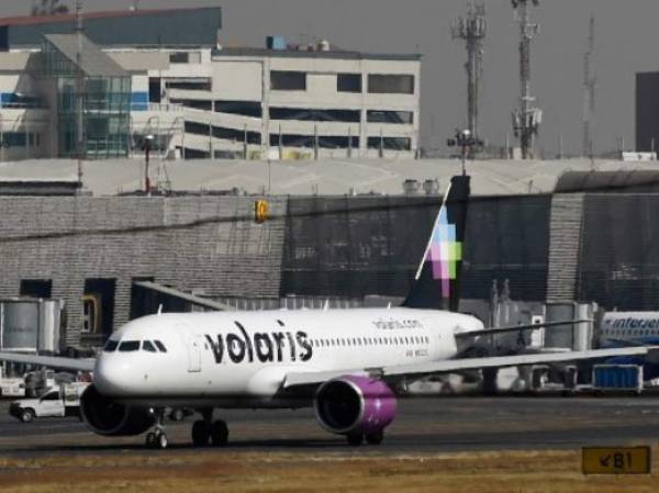 A plane of Mexico's Volaris is seen at Benito Juarez International Airport in Mexico City on January 17, 2018. - Mexican airline Volaris has ordered 80 Airbus A320 planes for a total $9.3 billion, with deliveries over the next eight years, the Mexican government said on January 16. (Photo by Alfredo ESTRELLA / AFP)