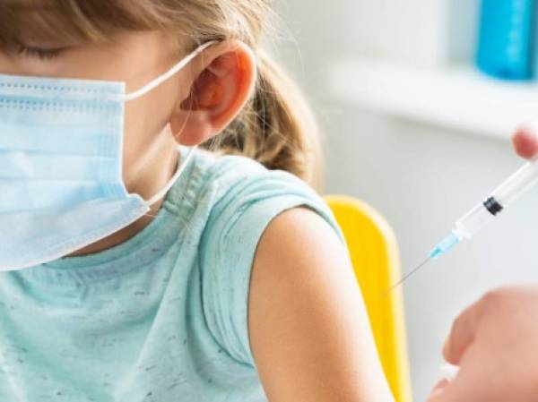 Little girl in the doctor's office is vaccinated. Syringe with vaccine against covid-19 coronavirus,flu,dangerous infectious diseases.Injection after clinical trials for human, child.Medicine concept.