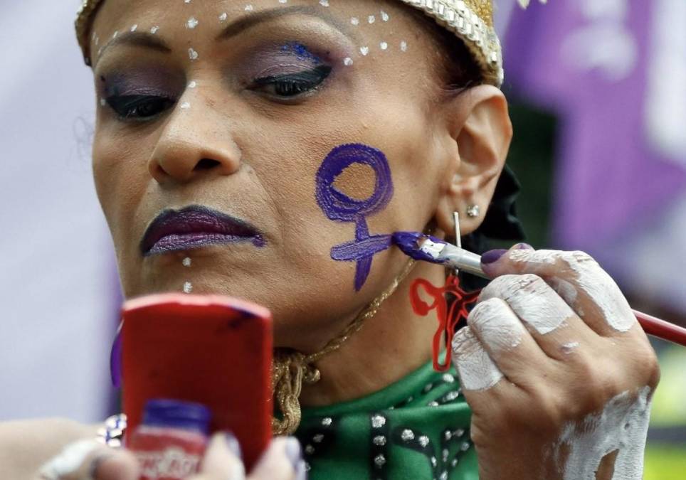 <i>Una mujer pinta un símbolo femenino en su rostro durante una manifestación para conmemorar el Día Internacional de la Mujer en Sao Paulo, Brasil, el 8 de marzo de 2024. FOTO Miguel SCHINCARIOL/AFP</i>