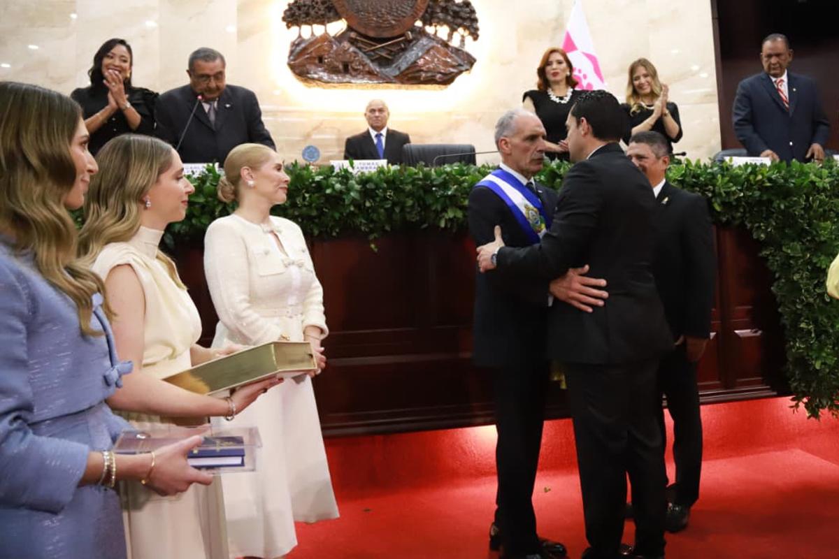 <i>El presidente del Congreso de Honduras José Tomás Zambrano (d) felicita al presidente de Honduras Nasry Asfura (c) durante su investidura este martes, en la sede del Congreso en Tegucigalpa (Honduras). EFE/ STR</i>