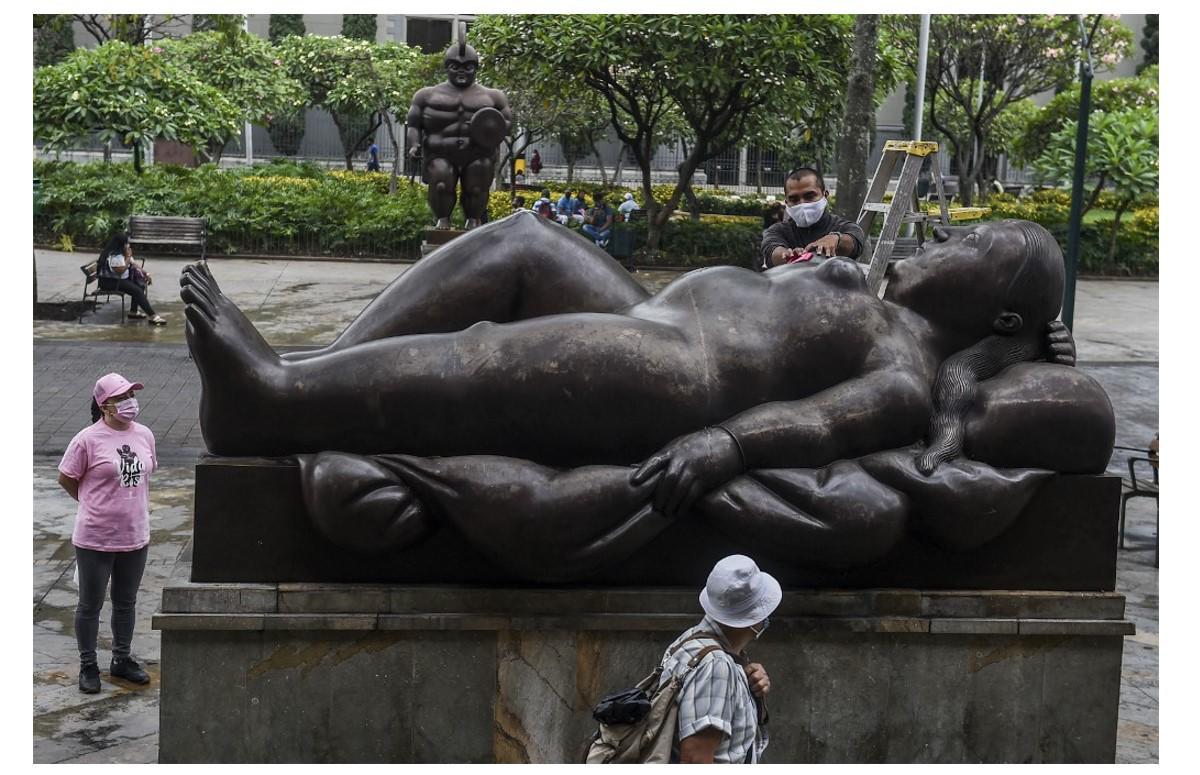 <i>Una mujer coloca un lazo rosa en una estatua del artista colombiano Fernando Botero como parte de una campaña durante el mes de concientización sobre el cáncer de mama, en Medellín, Colombia, el 19 de octubre de 2020.Joaquín SARMIENTO / AFP</i>