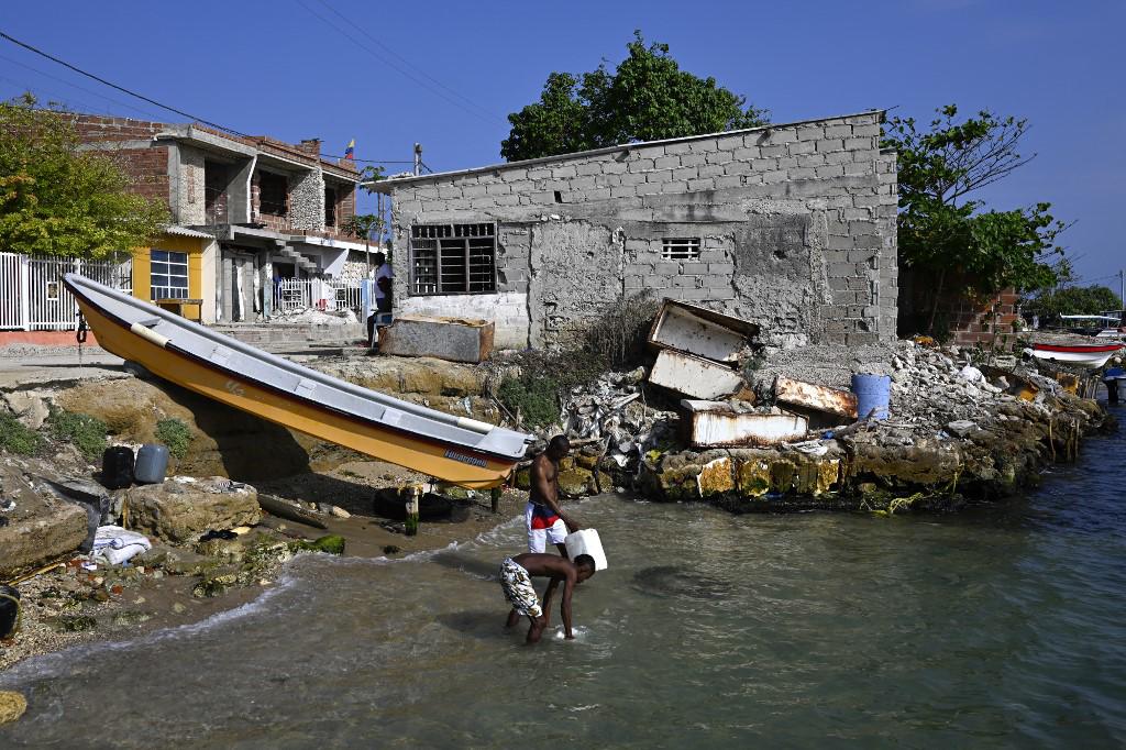 <i>Vista de las casas afectadas por el aumento del nivel del mar en la isla Tierra Bomba, Cartagena, Colombia, tomada el 24 de febrero de 2024. Cada año el nivel del mar sube y se traga la bahía de Cartagena a cuentagotas. Un cementerio arrastrado por las olas muestra los efectos del calentamiento global en la ciudad más turística de Colombia, que podría quedar parcialmente bajo el agua en este siglo. (Foto de Luis ACOSTA/AFP)</i>