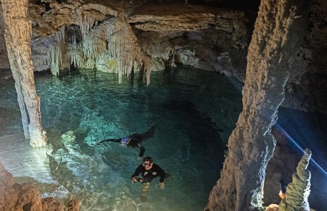 <i>Los activistas ambientales Guillermo DChristy y Roberto Rojo nadan dentro de un cenote cerca de Playa del Carmen, México, el 22 de abril de 2024. Es la pesadilla de los ambientalistas en México: la construcción del Tren Maya, el megaproyecto turístico del presidente saliente Andrés Manuel López Obrador, amenaza a los cenotes, los pozos subterráneos prehispánicos que abundan en la Península de Yucatán. FOTO CARL DE SOUZA/AFP</i>