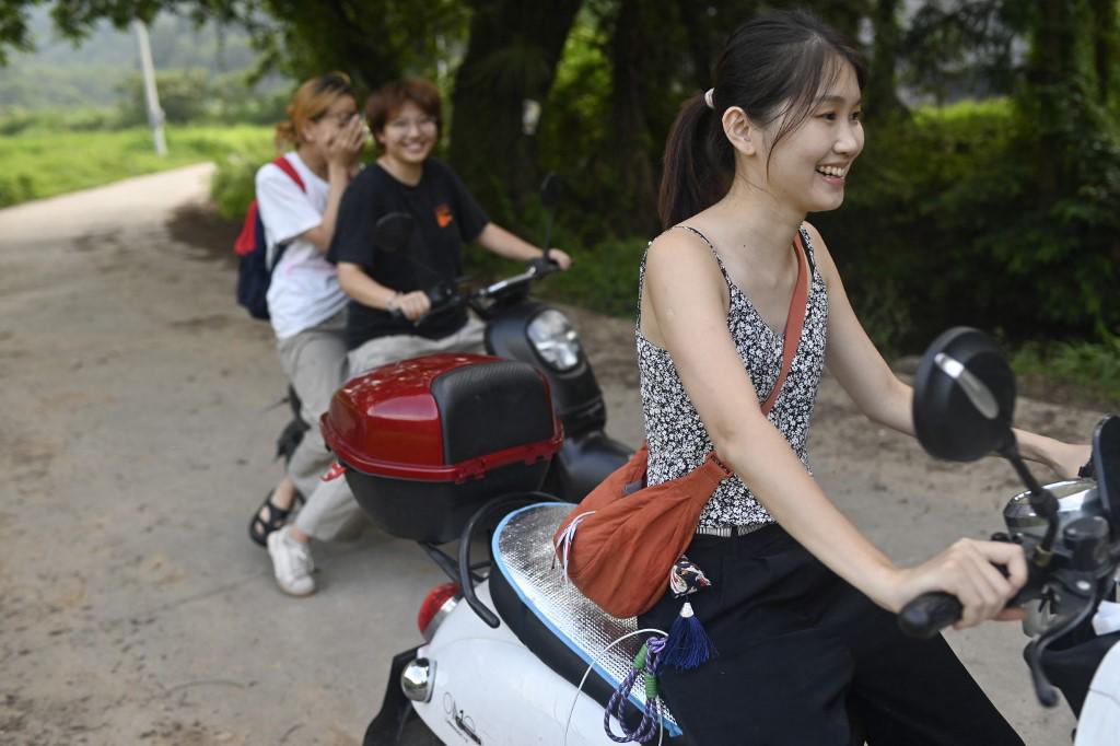 <i>Esta fotografía tomada el 25 de agosto de 2023 muestra a He Yun (derecha) montando una bicicleta eléctrica con amigos en Jingdezhen, provincia china de Jiangxi. (Foto de WANG Zhao / AFP) </i> <i>Esta fotografía tomada el 25 de agosto de 2023 muestra a He Yun (derecha) montando una bicicleta eléctrica con amigos en Jingdezhen, provincia china de Jiangxi. (Foto de WANG Zhao / AFP) </i>