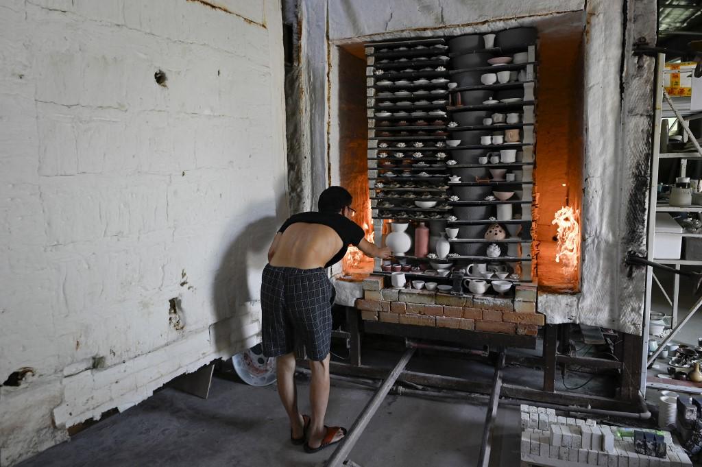 <i>Esta fotografía tomada el 26 de agosto de 2023 muestra a un hombre horneando productos de cerámica en un taller de horno en Jingdezhen, provincia china de Jiangxi. (Foto de WANG Zhao / AFP) </i> <i>Esta fotografía tomada el 26 de agosto de 2023 muestra a un hombre horneando productos de cerámica en un taller de horno en Jingdezhen, provincia china de Jiangxi. (Foto de WANG Zhao / AFP) </i>
