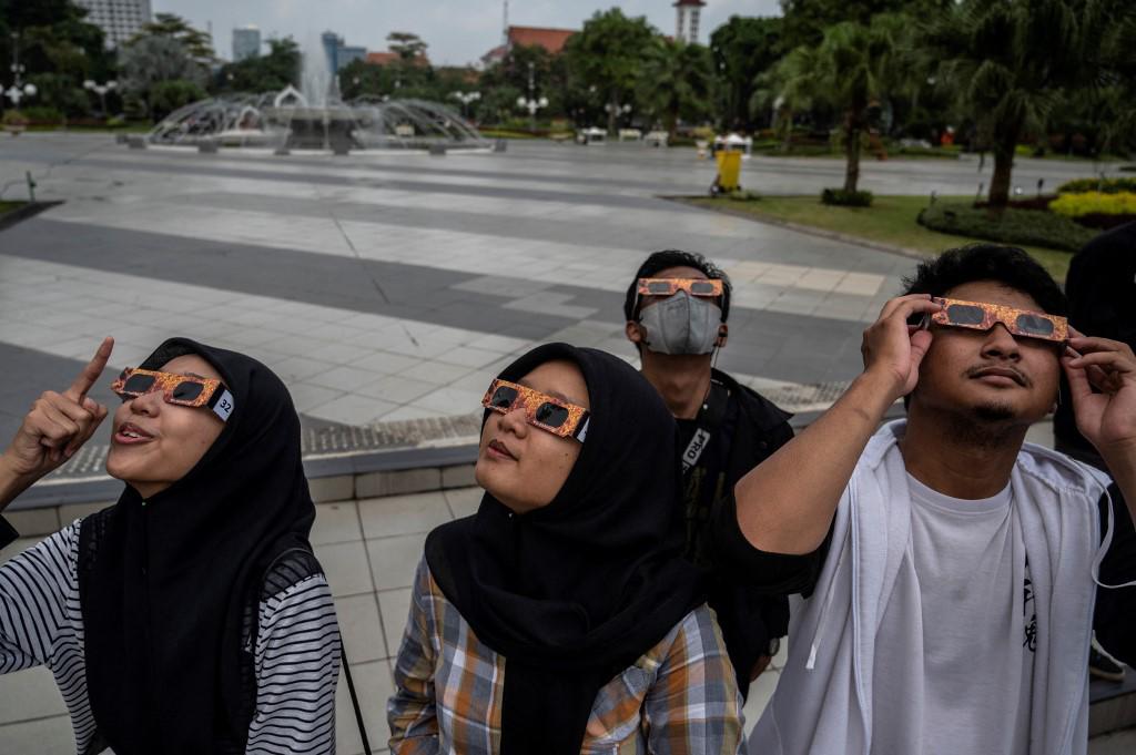 <i>La gente observa un eclipse solar parcial en Surabaya el 20 de abril de 2023. (Foto de Juni Kriswanto / AFP)</i> <i>La gente observa un eclipse solar parcial en Surabaya el 20 de abril de 2023. (Foto de Juni Kriswanto / AFP)</i>