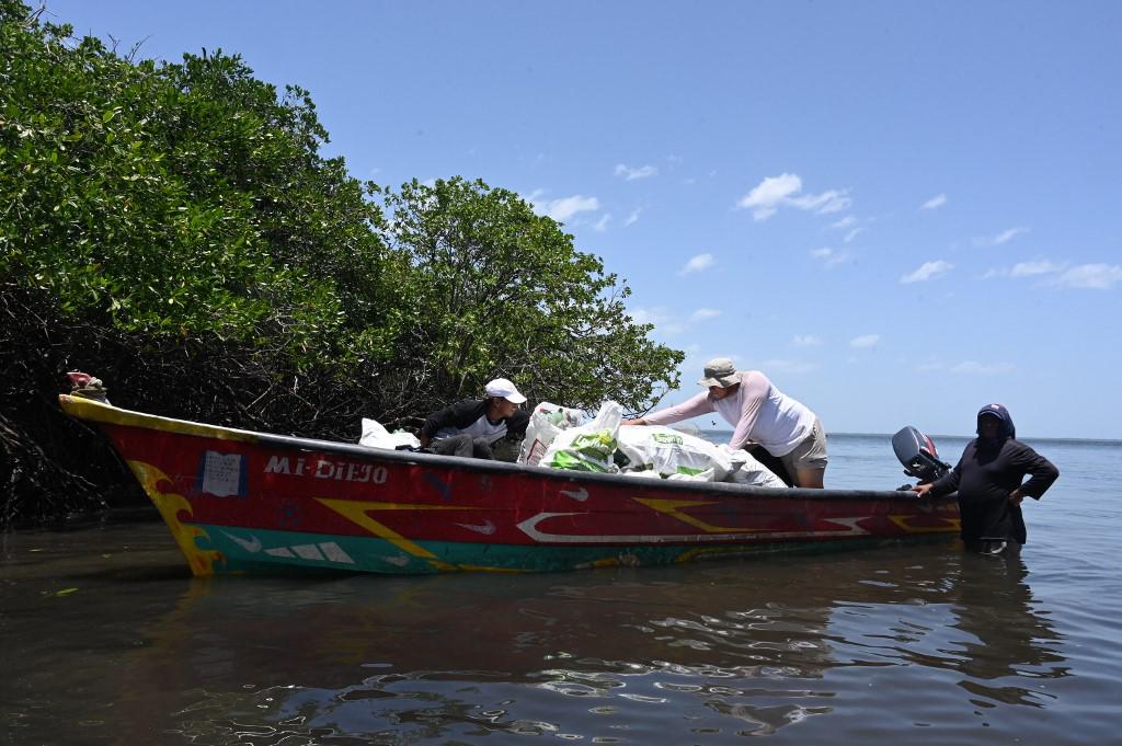 <i>Integrantes del no gubernamental Comité para la Defensa y Desarrollo de la Flora y Fauna del Golfo de Fonseca (CODDEFFAGOLF) realizan labores de limpieza en la Isla Los Pájaros, en la Bahía de San Lorenzo, en el Golfo de Fonseca, que comparte Honduras con El Salvador y Nicaragua, a 60 km al sur de Tegicigalpa, el 25 de julio de 2023. La Isla de Los Pájaros, repleta de bulliciosas aves marinas, está siendo afectada por la basura, principalmente plástico, que llega desde tierra firme luego de ser arrojada a los ríos que cruzan las ciudades y pueblos de Honduras, El Salvador y Nicaragua. (Foto por Orlando SIERRA / AFP)</i>