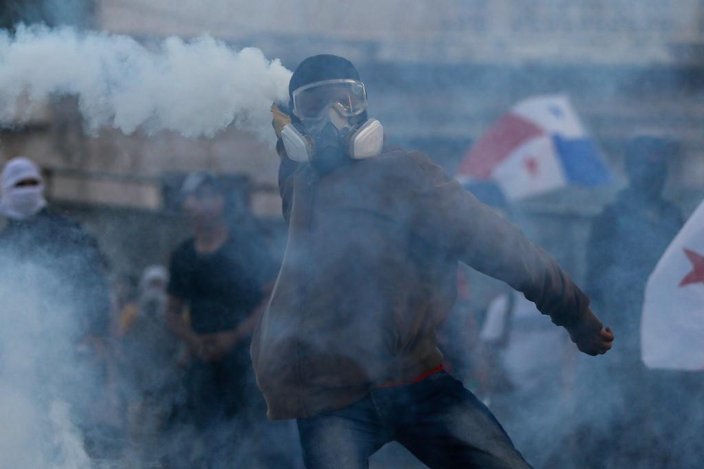 <i>Los manifestantes chocan con la policía antidisturbios durante una protesta contra el contrato de la empresa minera canadiense FQM, frente a la Asamblea Nacional en la Ciudad de Panamá el 23 de octubre de 2023. (Foto de Roberto CISNEROS/AFP)</i>