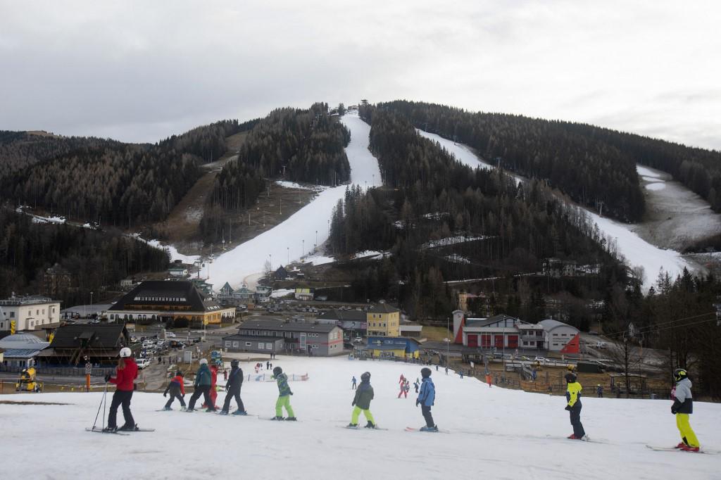 <i>Algunos esquiadores practican en el área de la escuela de esquí Semmering frente a la montaña Semmering con pistas de esquí con nieve artificial en el complejo de deportes de invierno Zauberberg im Semmering, Baja Austria, el 8 de enero de 2023. (Foto de Alex HALADA / AFP)</i>